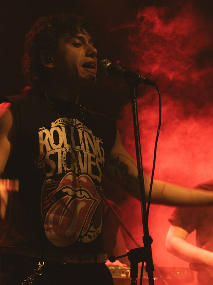 T. Maffia cantando entre humo rojo