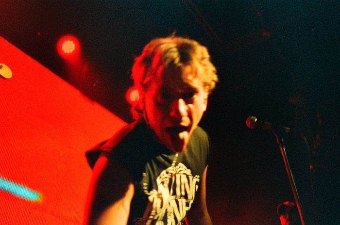 T. Maffia cantando con luces rojas de fondo